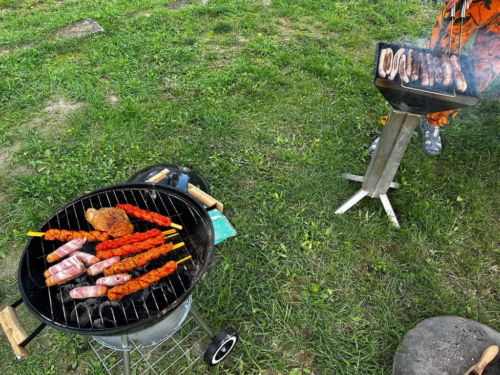 Grillgut auf zwei Holzkohlegrills