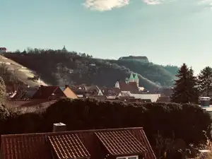 Stadtansicht mit Kirchtürmen und Burg auf dem Hügel